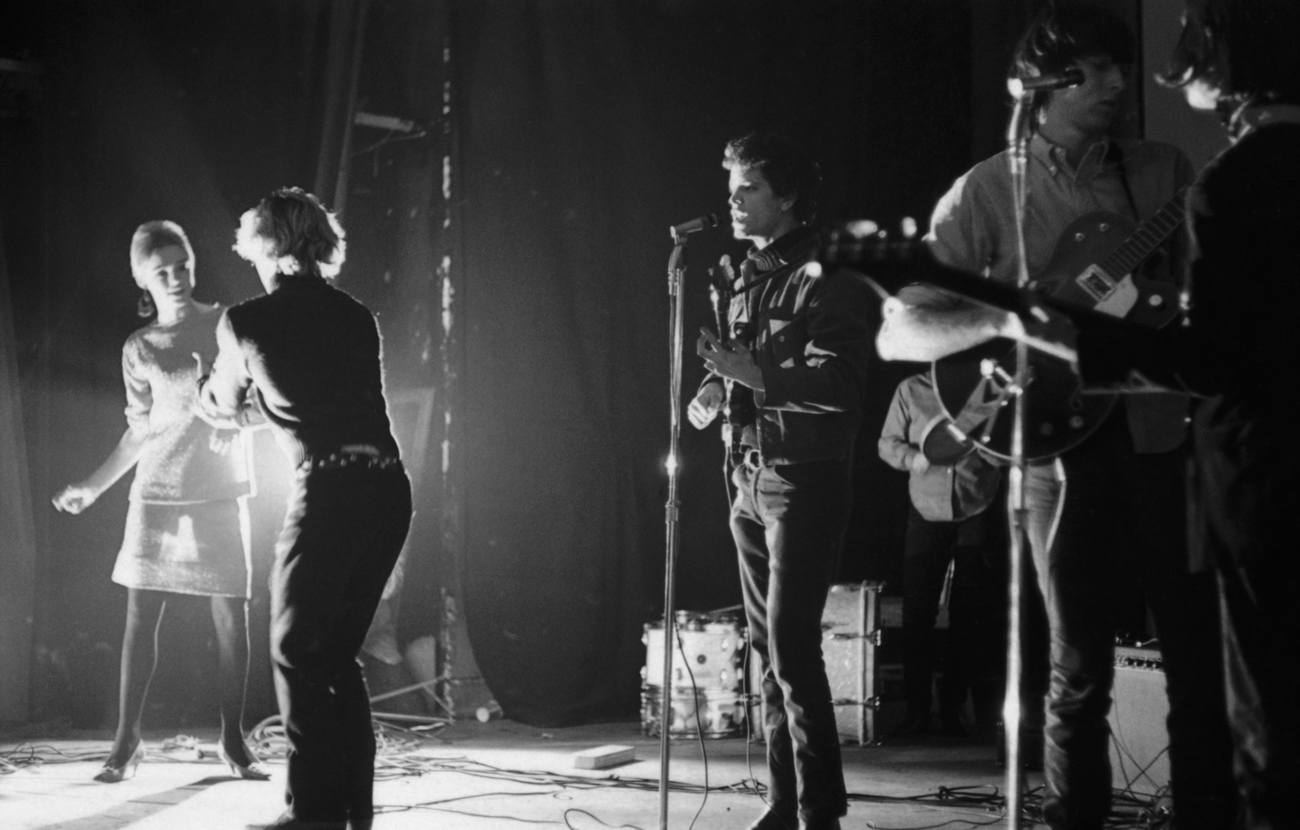 De gauche à droite : Edie Sedgwick, Gerard Malanga, Lou Reed, Sterling Morrison et John Cale. Les Velvet Underground en concert à la Cinémathèque des cinéastes de New York, en février 1966. © Adam Ritchie/Redferns/GettyImages.