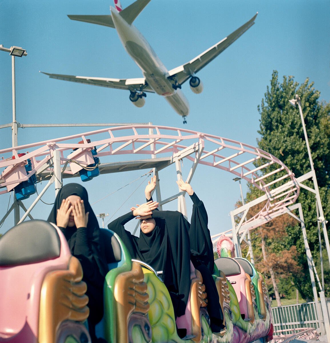 Sabiha Çimen, A plane flies low over students riding a train at a funfair over the weekend (2018). © Sabiha Çimen / Magnum Photos.