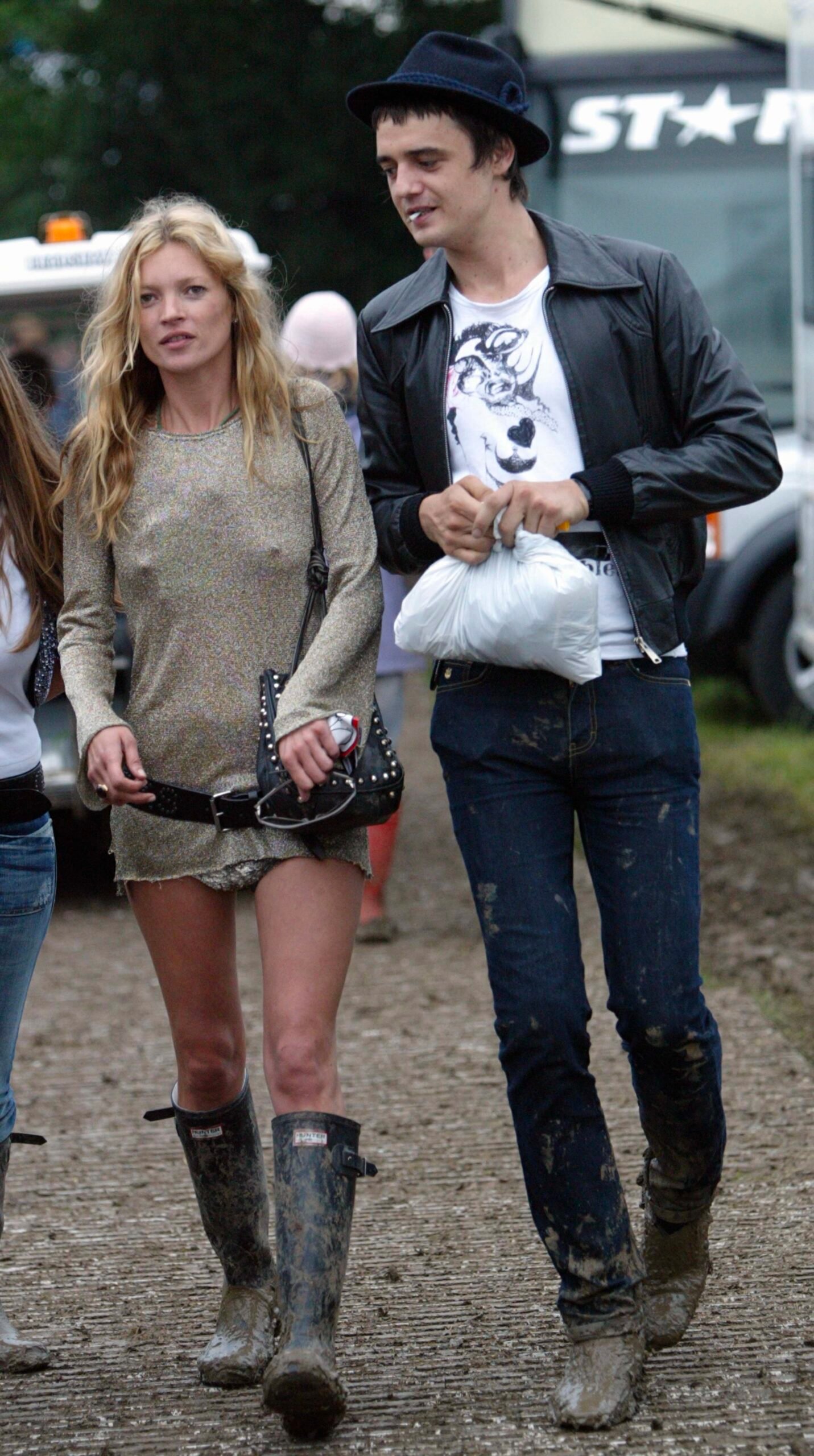 Model Kate Moss and singer Pete Doherty walk backstage during the 2005 Glastonbury Festival being held at Worthy Farm in Pilton, near Glastonbury on June 25, 2005 in Somerset, England. The festival, founded in 1970, has grown into one of the largest outdoor green field festivals in the world.