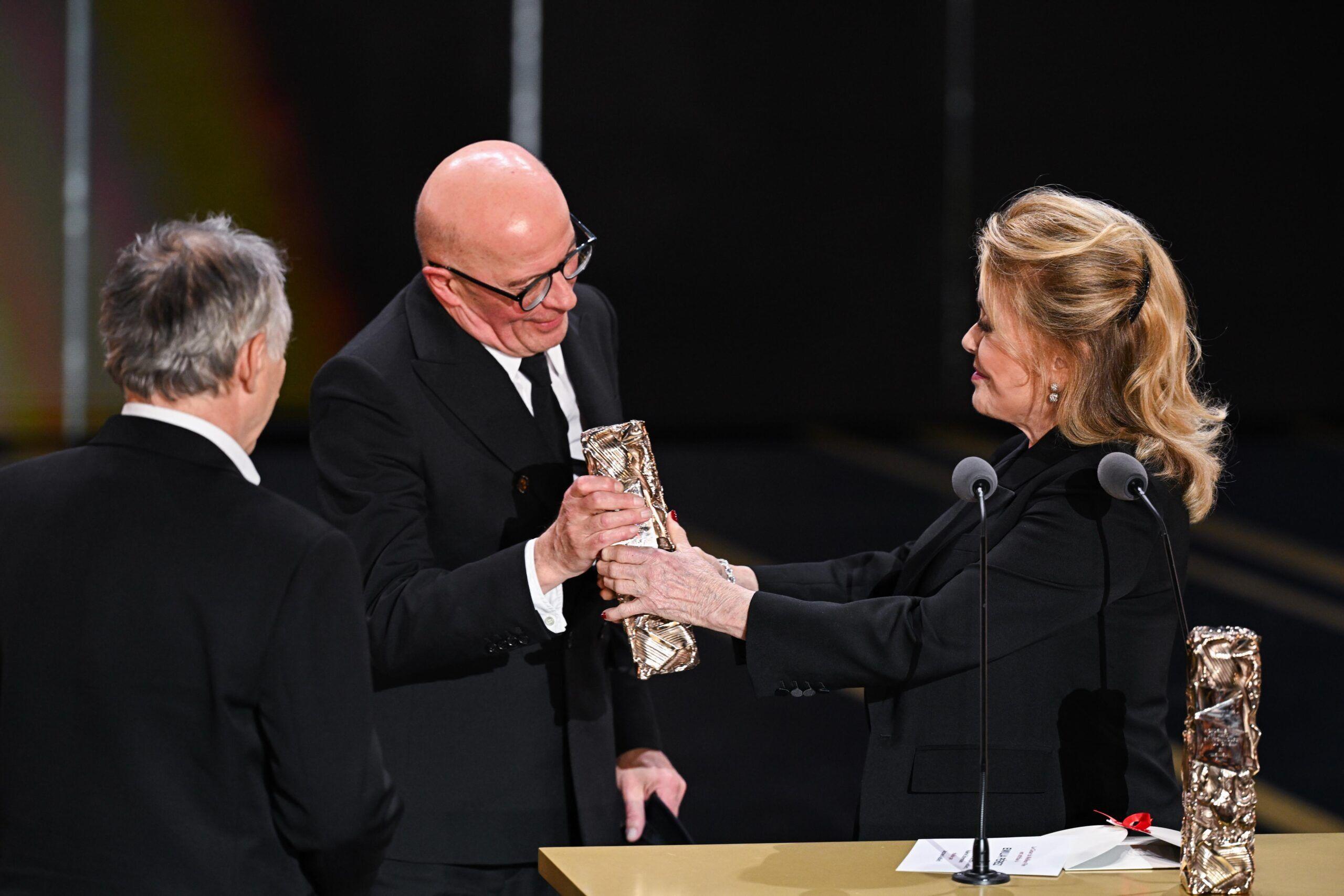 Jacques Audiard recevant le César du meilleur film pour Emilia Pérez, film coproduit par Saint Laurent Productions, et Catherine Deneuve aux César 2025 © Saint Laurent.