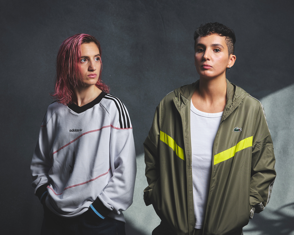 Fatima Daas et Aloïse Sauvage prennent la pose côte à côté sur un arrière-plan gris.