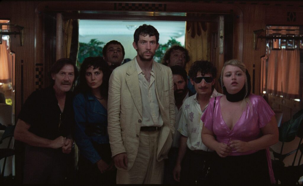 Josh O'Connor prend la pose en costume blanc dans le film La Chimera (2023) d'Alice Rohrwacher.