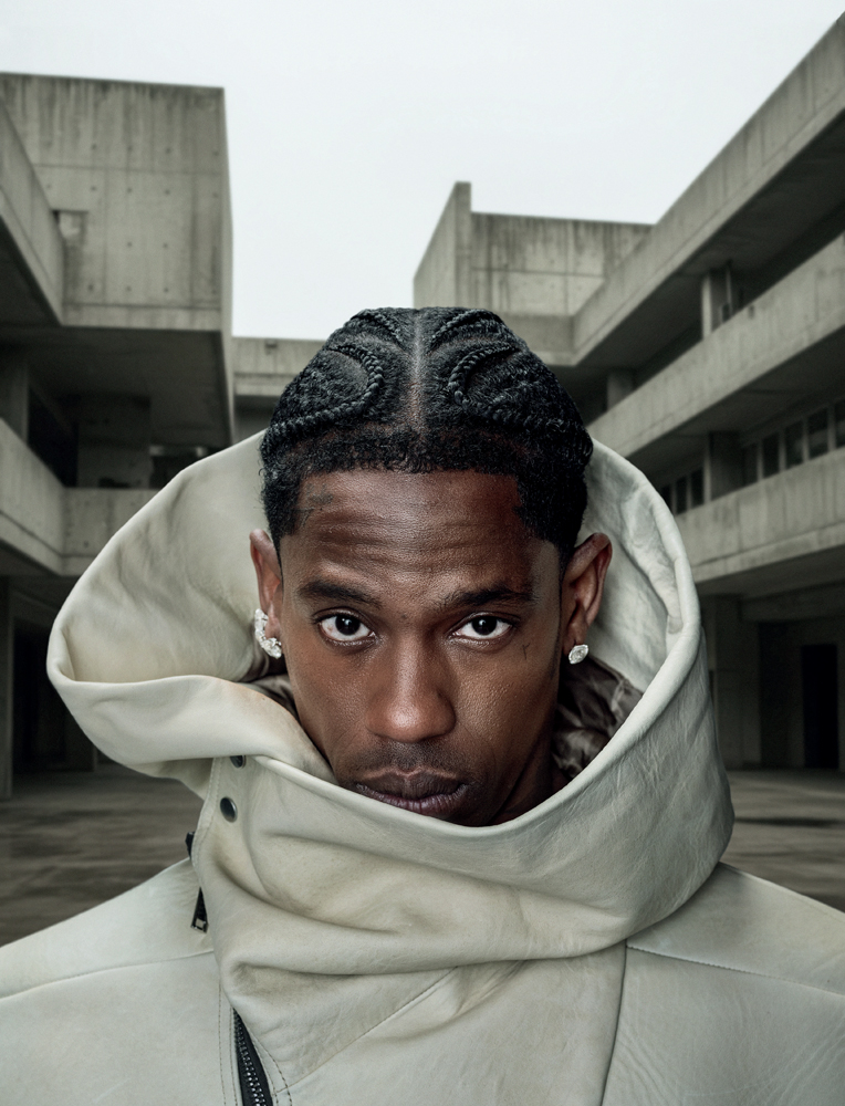 Portrait de Travis Scott regardant la caméra dans un blouson en cuir blanc.