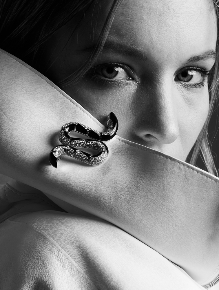 Cliché en gros plan de l'actrice, en noir et blanc, le visage partiellement masqué par une veste.