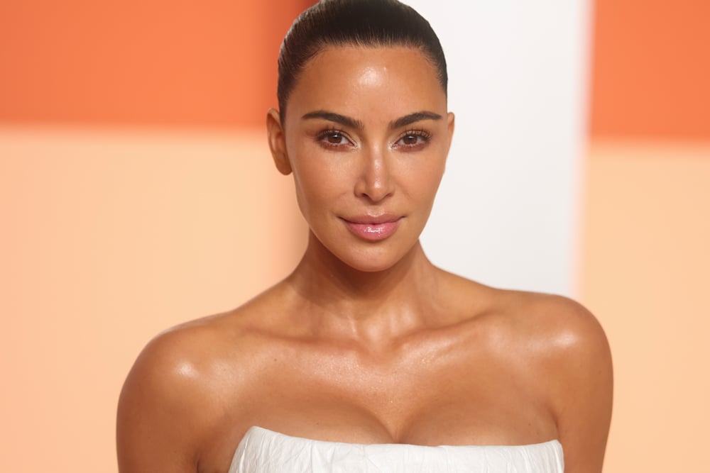 Starring in the film The Fifth Wheel, Kim Kardashian strikes the pose in a white dress on a photocall.