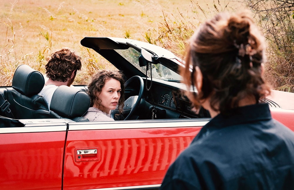 Paula Beer à bord d'un véhicule rouge dans le film Miroirs No. 3 de Christian Petzold.