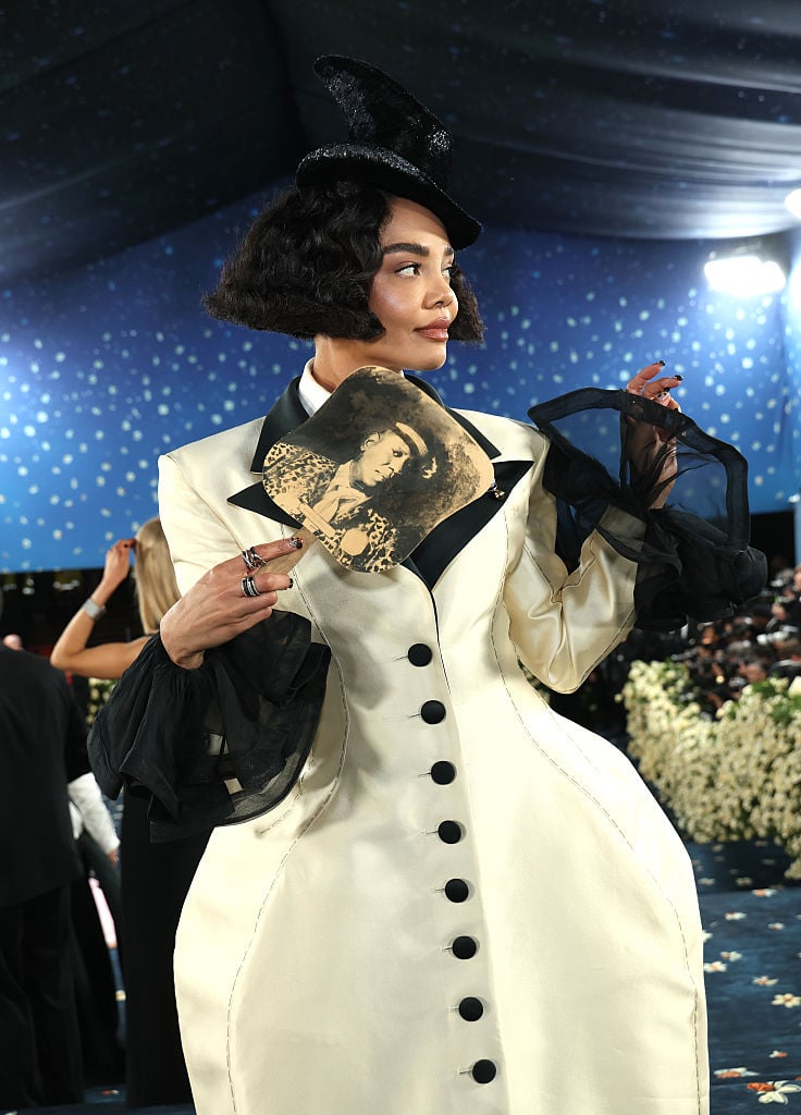 Tessa Thompson en manteau blanc tailoring Prabal Gurung avec un éventail Andre Leon Talley au Met Gala 2025.