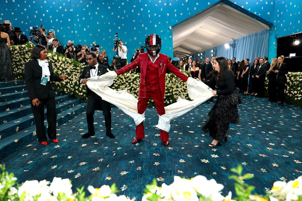 Damson Idris en costume et casque de F1 sginés Tommy Hilfiger au Met Gala 2025. © Dimitrios Kambouris/Getty Images for The Met Museum/Vogue.