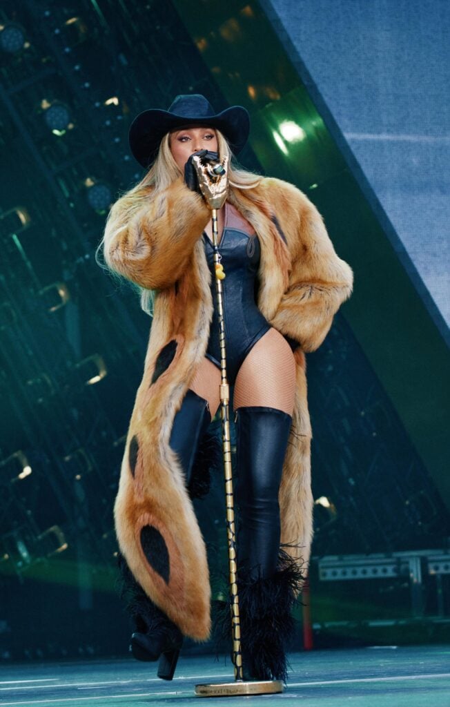 Photo de la chanteuse Beyoncé en manteau à fourrures marron custom Ferragamo pendant sa tournée Cowboy Carter Tour.