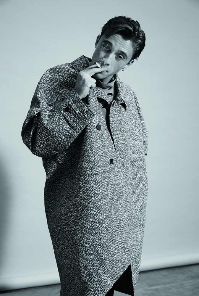 Benjamin Voisin en manteau oversize en coton technique imprimé et sous-pull à col roulé en mousseline de soie, GUCCI.