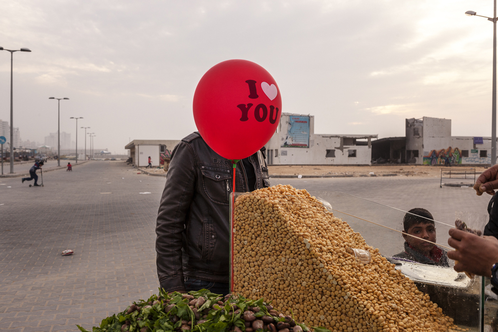 Un homme debout derrière un ballon dans une échoppe de rue, au port de Gaza. Le port, principal lieu de rassemblement des pêcheurs, est également un important centre social à Gaza.