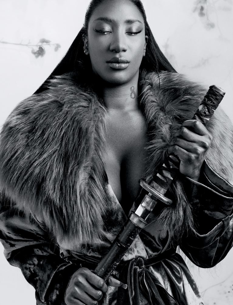 Aya Nakamura en manteau de fourrure avec un sabre. 