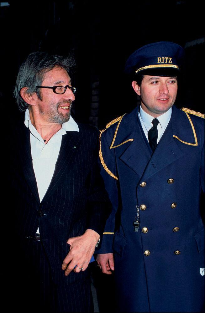 Serge Gainsbourg, coutumier des bars de l’hôtel Ritz, posant avec un portier en 1991