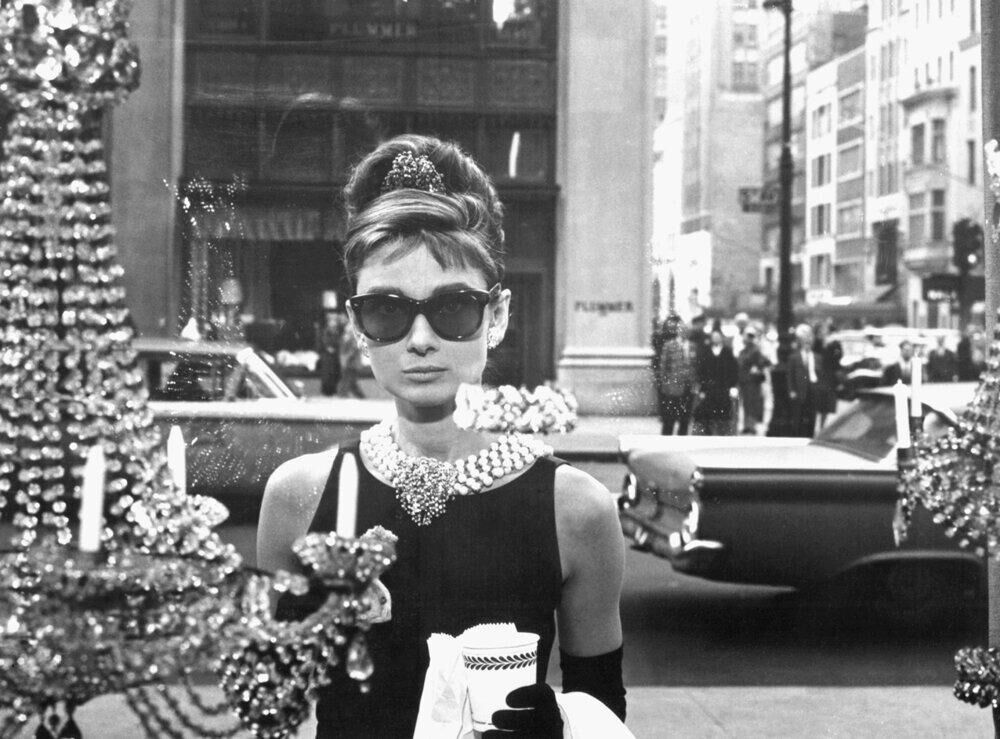 Audrey Hepburn porte une paire de lunettes de soleil Givenchy Cat Eye sur le tournage de Breakfast at Tiffany's (1961). Paramount Pictures/Sunset Boulevard/Corbis via Getty Images.