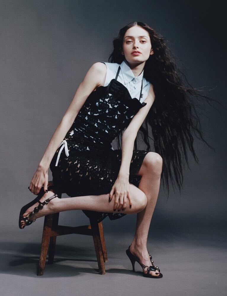 Solann porte un haut, une jupe, une chemise et sandales MIU MIU.