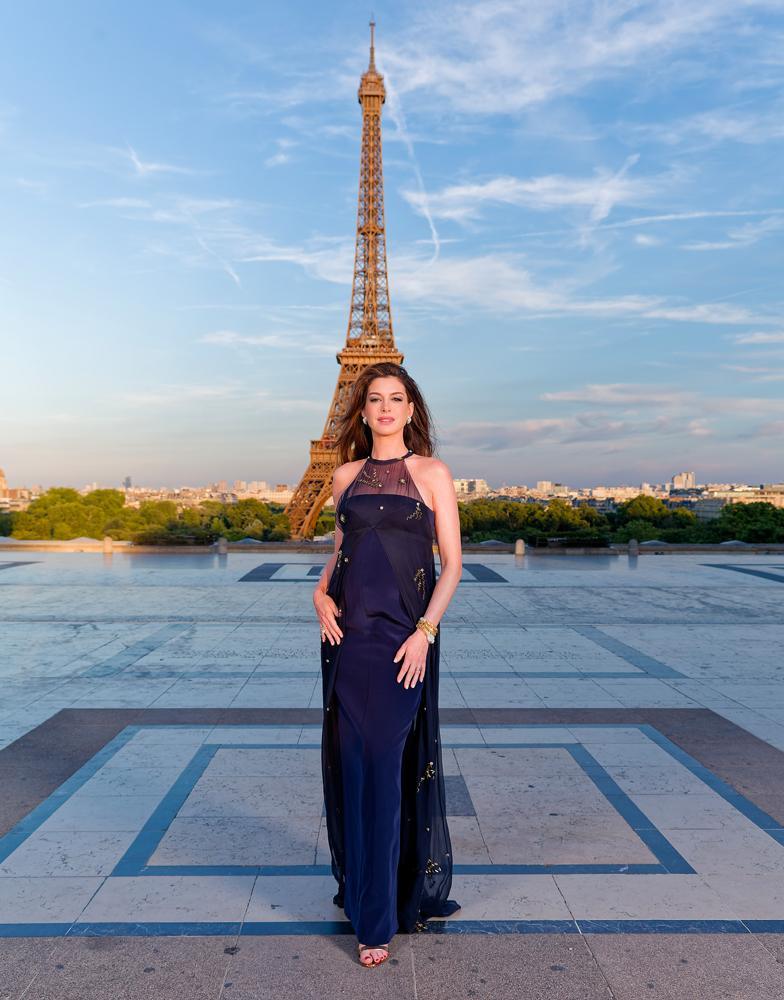 Anne Hathaway en robe Prada bleu et bijoux Bulgari à Paris pour la promotion de L'Odyssée.