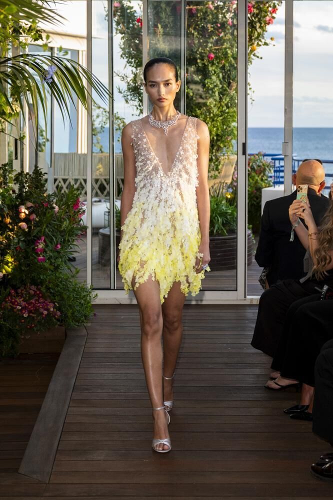 Une robe haute couture dégrandée blanche et jaune courte à bretelles ornée de fleurs du défilé Caroline's Couture 2026