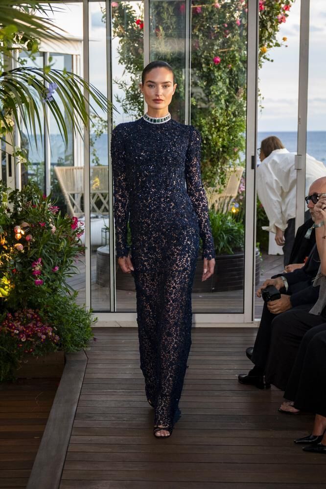 Une robe longue haute couture Caroline's Couture à manches longues et à paillettes bleues nuit du défilé Caroline's Couture 2026 ainsi qu'un collier Chopard
