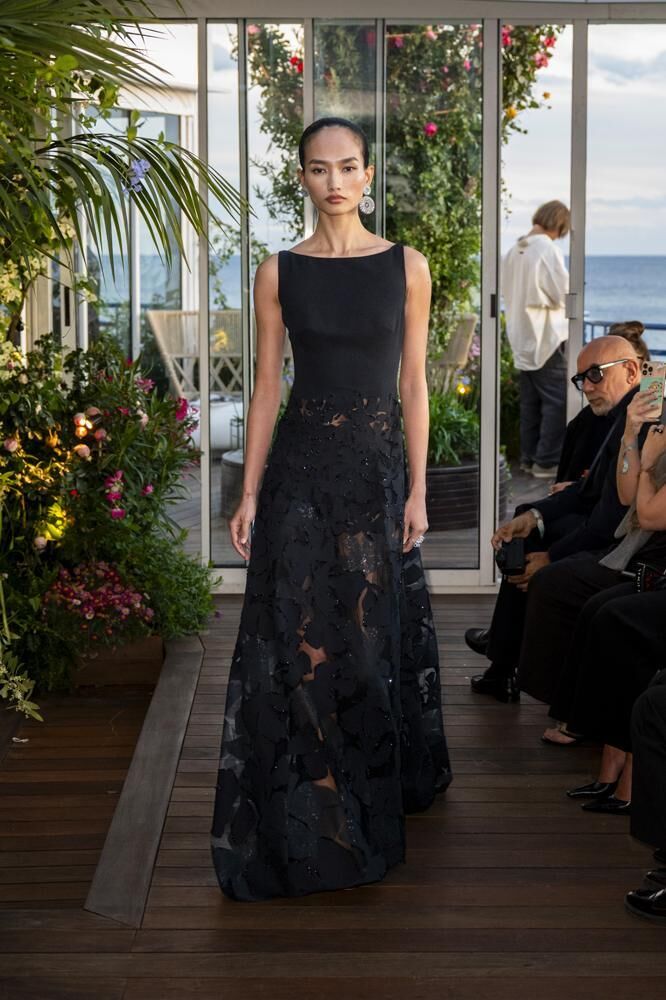 Une robe haute couture col bateau noire à grosses fleurs du défilé Caroline's Couture 2026 et des boucles d'oreille haute joaillerie Chopard