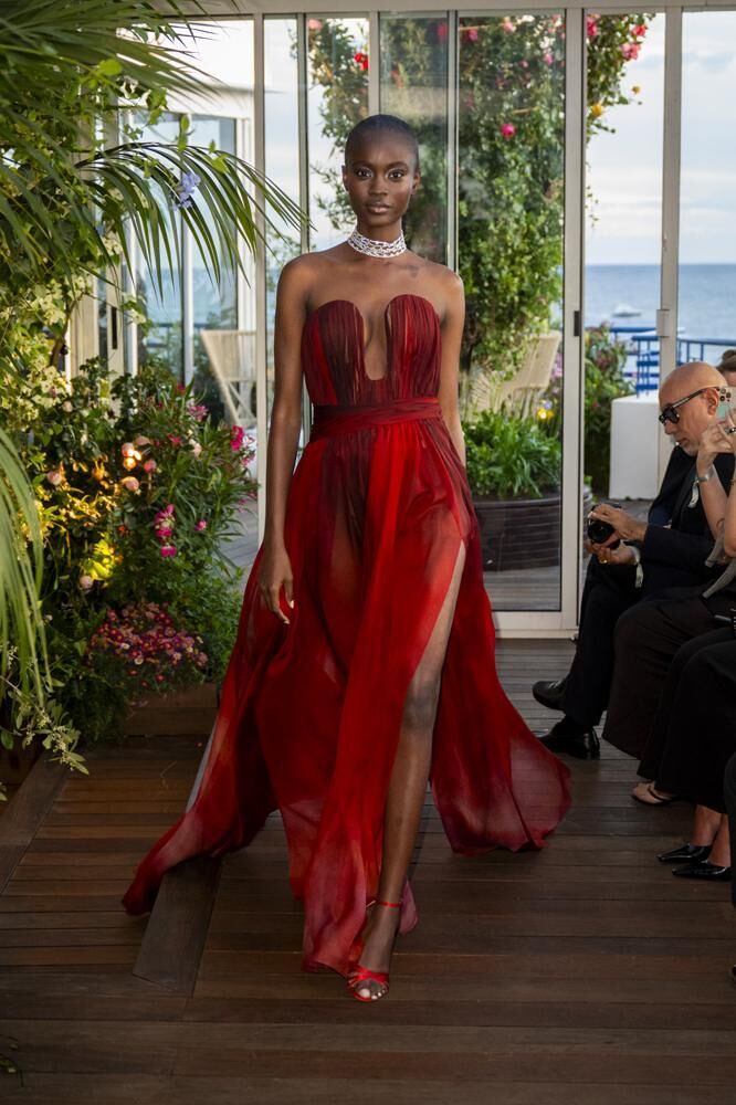 Une robe haute couture longue Caroline's Couture dégradée de rouge et un choker en diamants Chopard haute joaillerie.