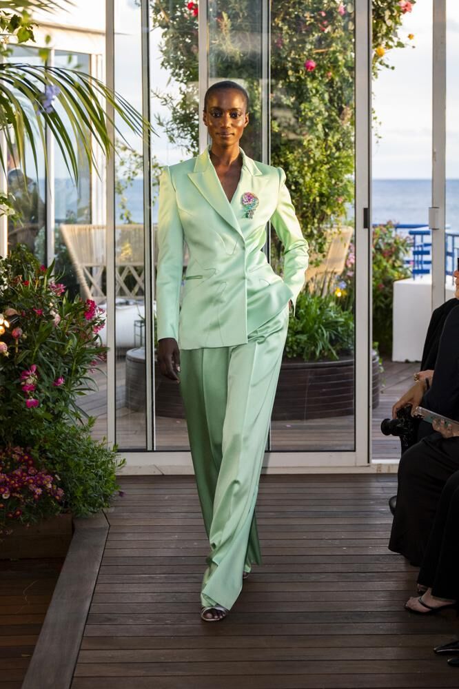 Un tailleur haute couture vert en soie avec une broche du défilé Caroline's Couture 2026