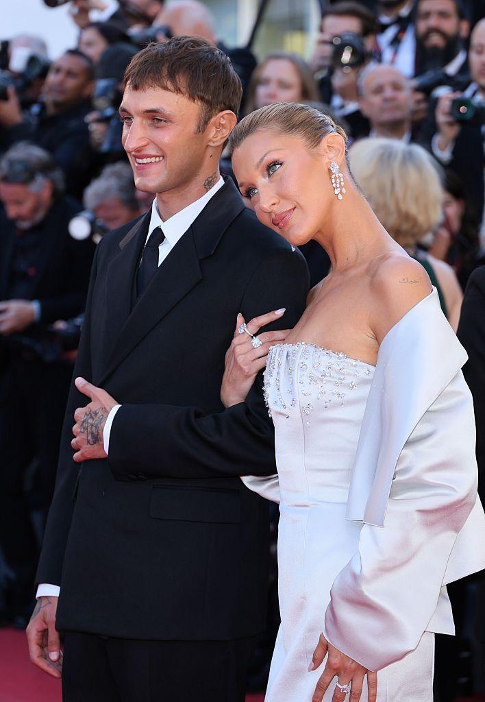 Bella Hadid en robe en satin grise bustier Prada et bijoux Chopard, avec son frère Anwar Hadid en costume Prada noir au Festival de Cannes 2026.