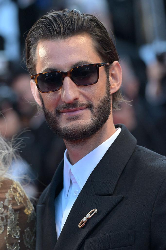 Pierre Niney avec la broche Serpent Bohème Vintage en or jaune et en diamants Boucheron et costume noir au Festival de Cannes 2026.