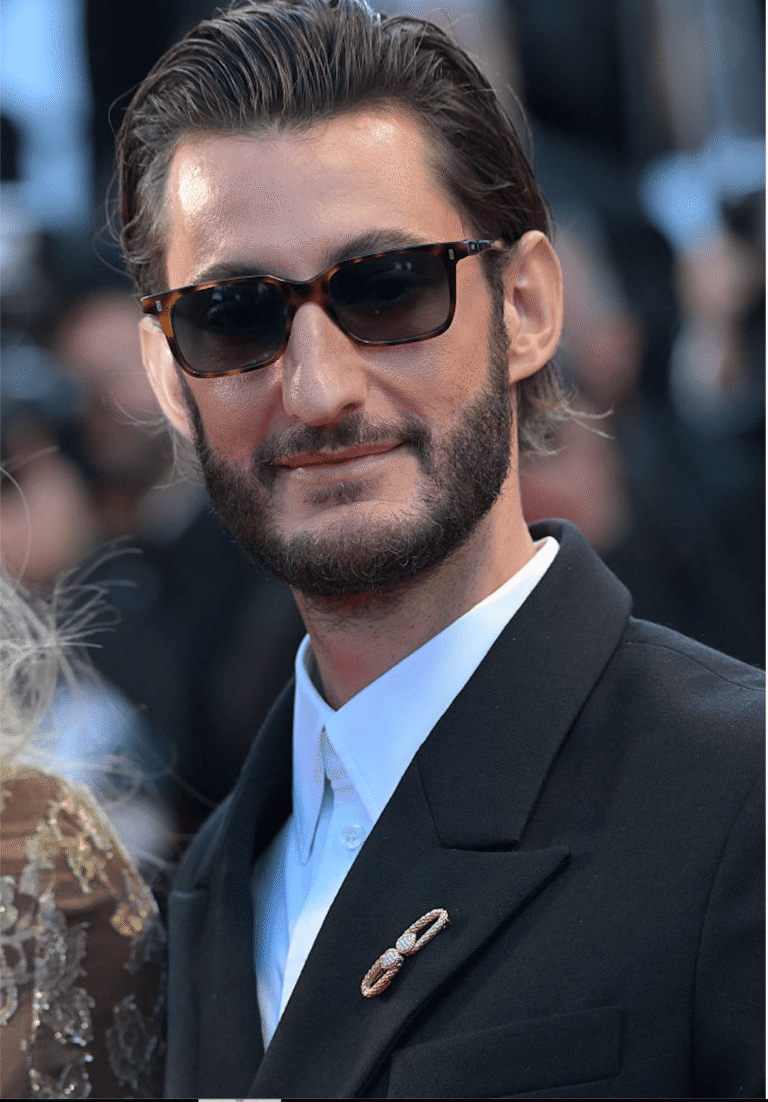 Pierre Niney avec la broche Serpent Bohème Vintage en or jaune et en diamants Boucheron et costume noir au Festival de Cannes 2026.