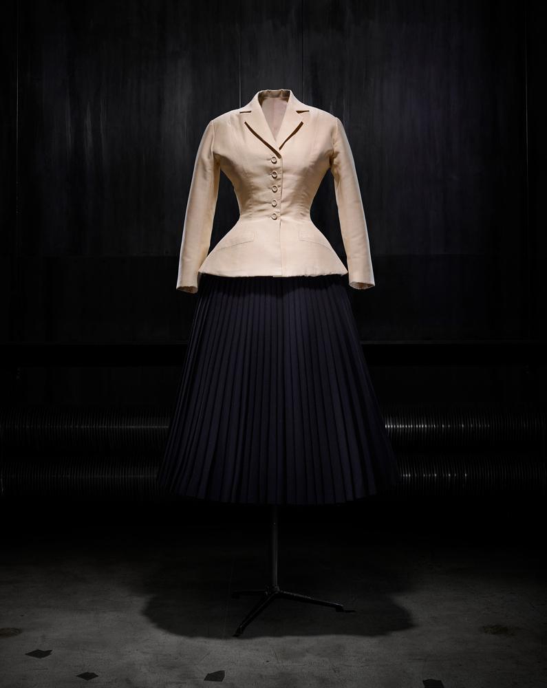 Tailleur d’après-midi Bar composé d’une jaquette en shantung naturel et d’une jupe corolle plissée en lainage noir, haute couture printemps-été 1947 par Christian Dior