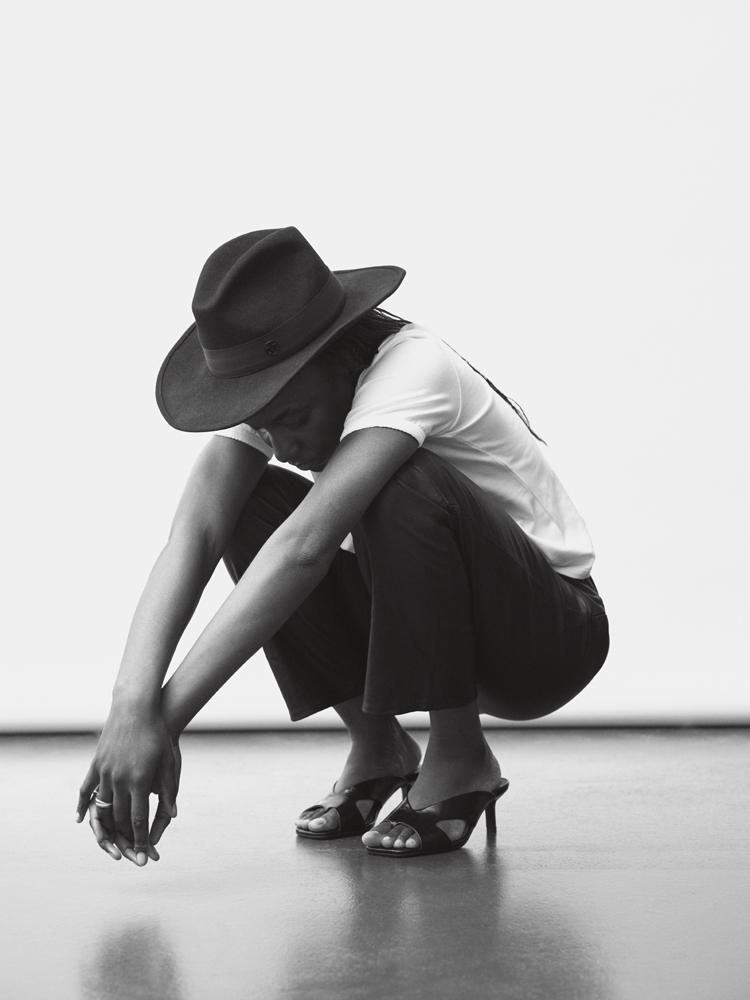 L'actrice Suzy Bemba en Tee-shirt en coton, pantalon en cuir, escarpins en cuir Sézane.