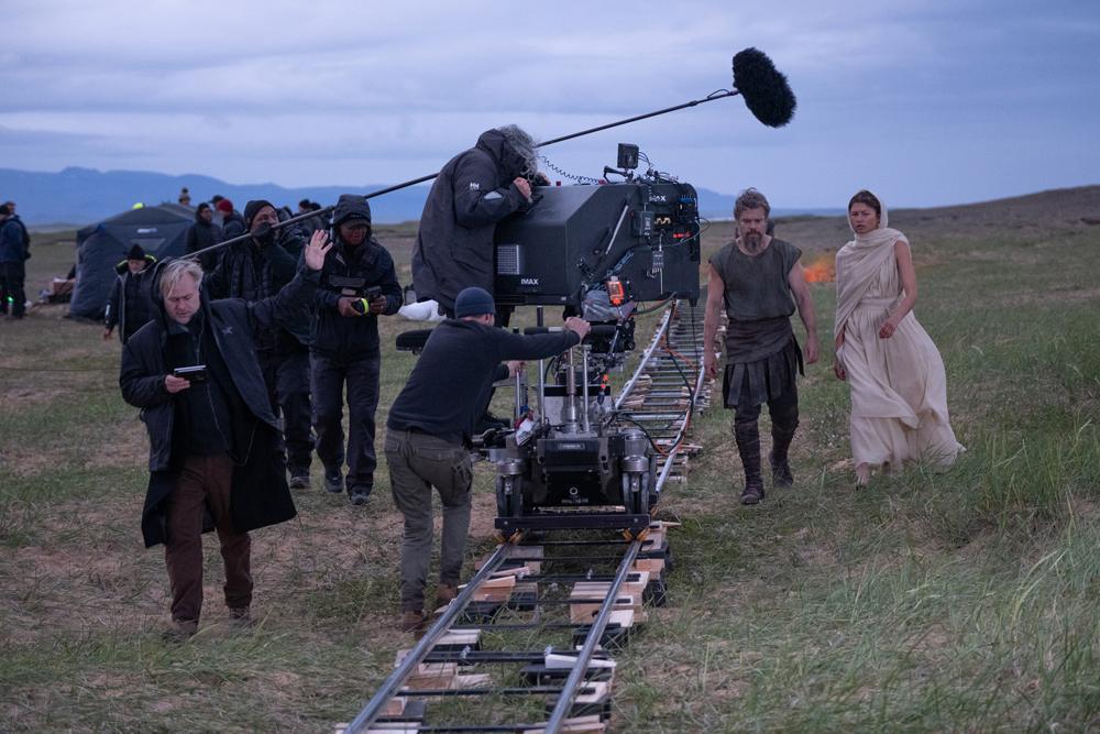 Le réalisateur Christopher Nolan (à gauche du cadre) avec Matt Damon (dans le rôle d'Ulysse) et Zendaya (dans le rôle d'Athéna), sur le tournage de son film *THE ODYSSEY*, écrit, produit et réalisé par Christopher Nolan.
