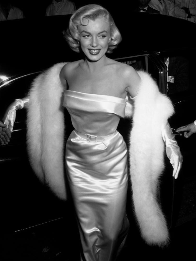 Marilyn Monroe à la première du film La joyeuse parade en 1964 avec une robe blanche bustier et une fourrure